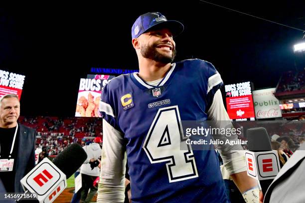 Dak Prescott of the Dallas Cowboys celebrates on the field after defeating the Tampa Bay Buccaneers 31-14 in the NFC Wild Card playoff game at...