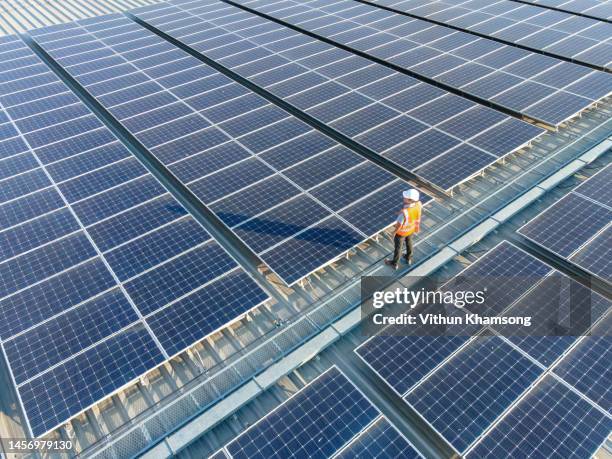 aerial view of engineers working at solar panels roof - aerial view construction workers stock-fotos und bilder