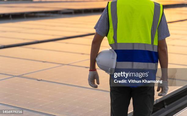 engineers working at roof and helmet at solar panels on sunset. - power occupation stock pictures, royalty-free photos & images