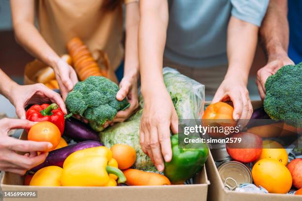 details von volunteer mit box mit essen für arme - essensausgabe stock-fotos und bilder