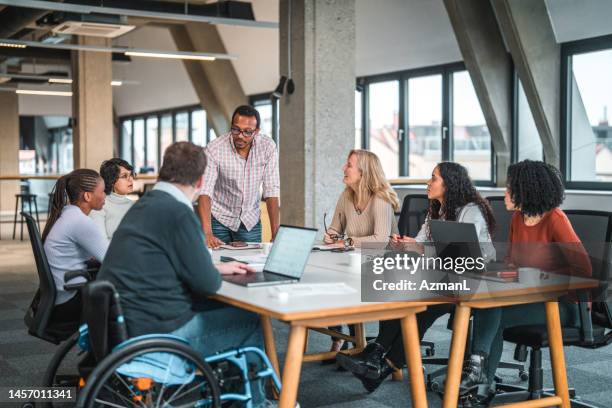 big group of multi ethnic people and one disabled man having a work meeting - inclusão social imagens e fotografias de stock