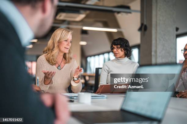man observing female colleagues discussing ideas - effective stock pictures, royalty-free photos & images