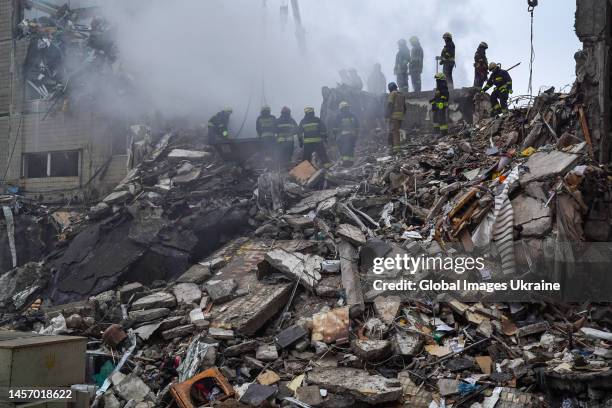 Rescuers search people trapped under the rubble of a high-rise residential building hit by a missile on January 15, 2023 in Dnipro, Ukraine. On...