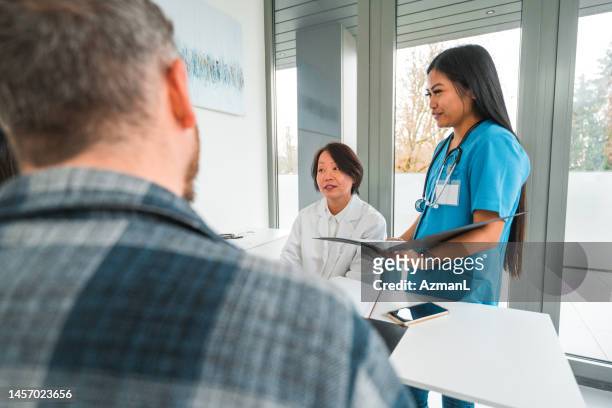 professional chinese female physician talking with a mixed race couple - dermatologists talking to each other patient stock pictures, royalty-free photos & images