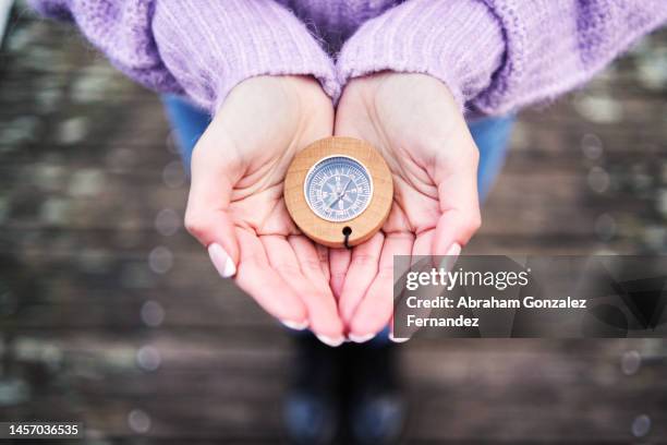 close-up of a woman's hands holding a compass. - compass north foto e immagini stock