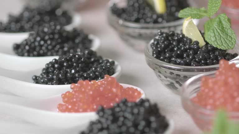 Salted Rae Red and black caviar in dishes. Elite salmon caviar and black Beluga ...