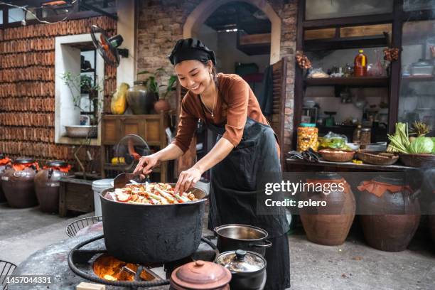 young vietnamese female chef cooking on open fire in restaurant - hot vietnamese women stock pictures, royalty-free photos & images