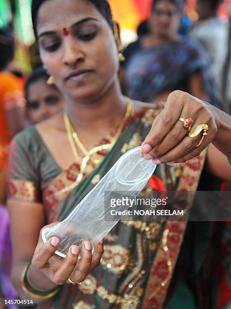 Indian volunteer B.Jyothi from the Integrated Rural Development Services explains the usage of female condom near the Red Ribbon Express-III train...