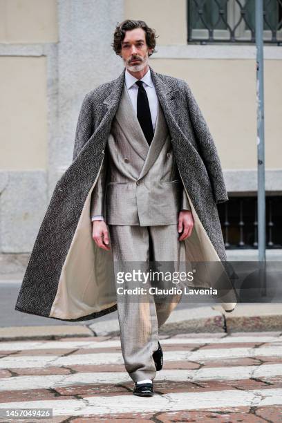 Richard Biedul is seen wearing a pied de poule long coat, white shirt, tie, grey silk double-breasted Giorgio Armani suit and black loafer outside...