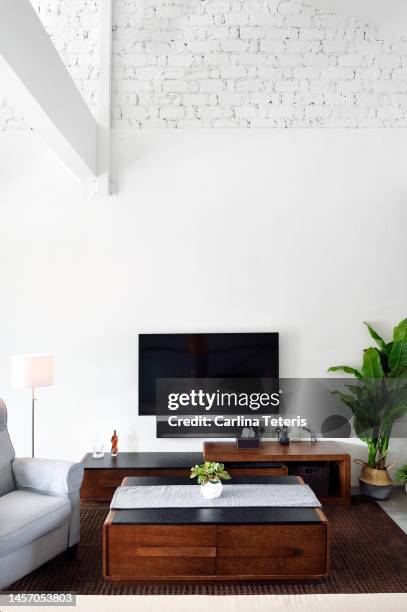 living room in a modern, stylish loft apartment - vertical tv stock pictures, royalty-free photos & images