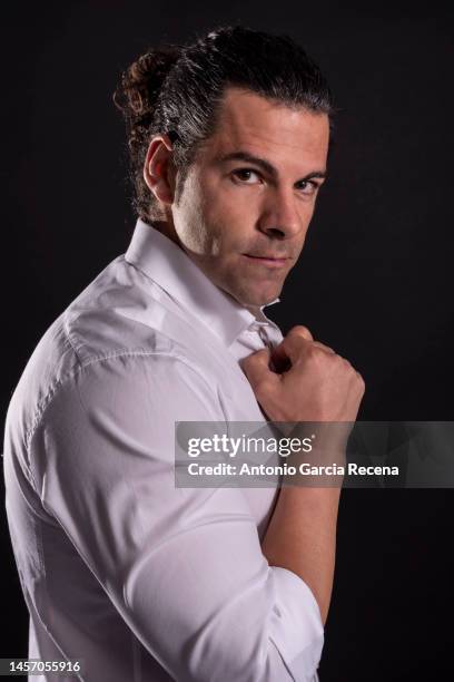 portrait of spanish man with shirt and long hair in tail on black studio background - seduzione foto e immagini stock