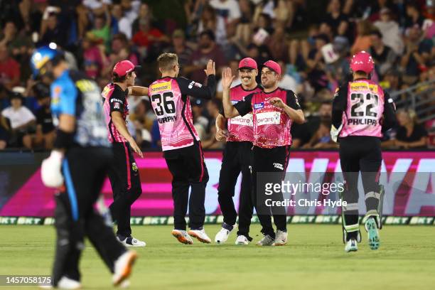 Moises Henriques of the Sixers celebrates with team mates after taking a catch during the Men's Big Bash League match between the Sydney Sixers and...