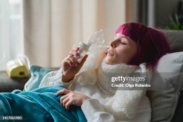 flu and cold season. woman doing inhalation with nebulizer mask at home - anthrax 個照片及圖片檔