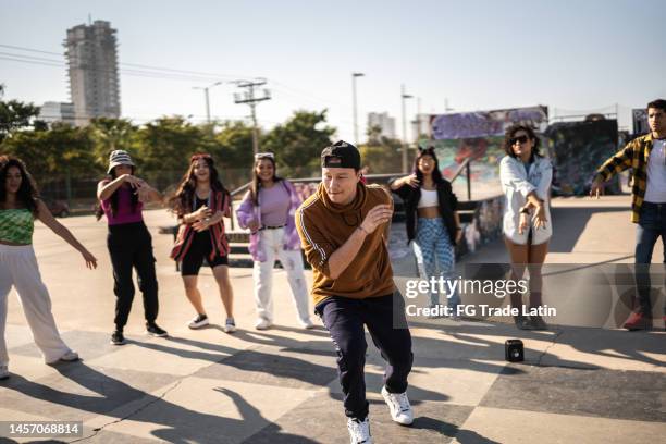 young man breakdancing during street party with her friends outdoors - break dance city stock pictures, royalty-free photos & images