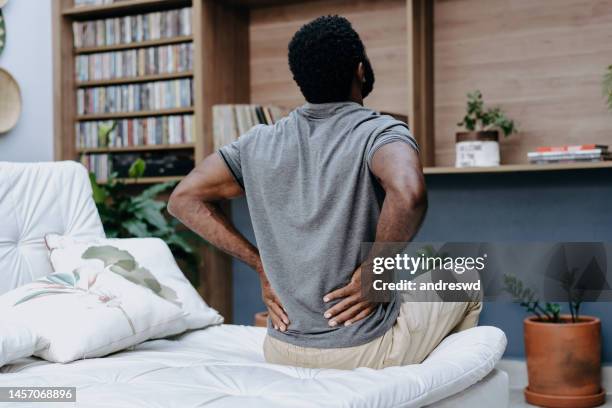 man wakes up with back pain - backache stock pictures, royalty-free photos & images