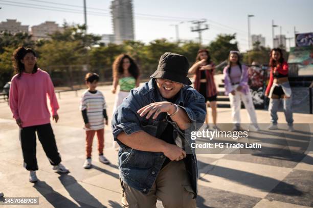 young man breakdancing during street party with her friends outdoors - gangsta rappers stock pictures, royalty-free photos & images