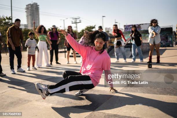 junge frau beim breakdance beim straßenfest mit ihren freunden im freien - breakdancing stock-fotos und bilder