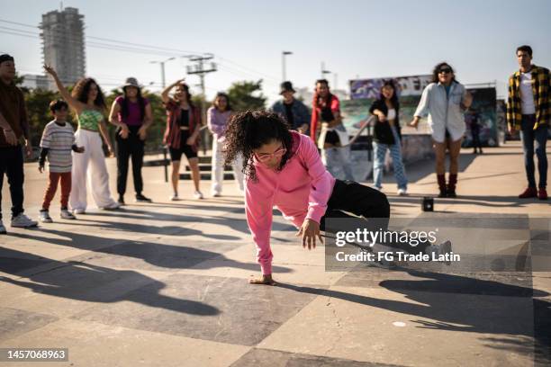 young woman breakdancing during street party with her friends outdoors - fab fragment stock pictures, royalty-free photos & images