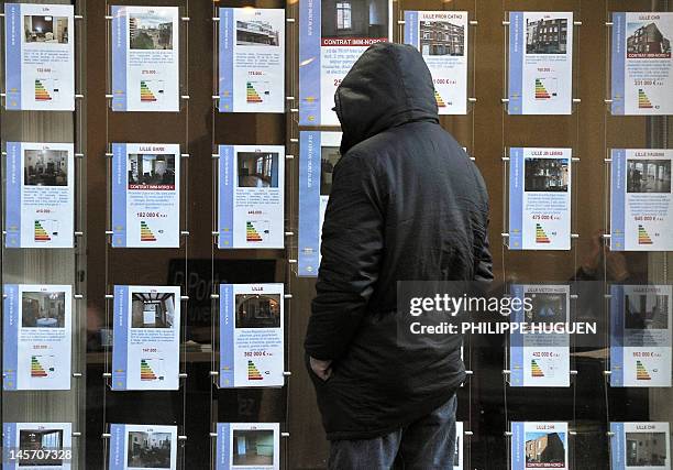 Man reads anouncements of a real estate agent on January 30, 2012 in Lille, northern France. The French construction industry is set to shed 35,000...