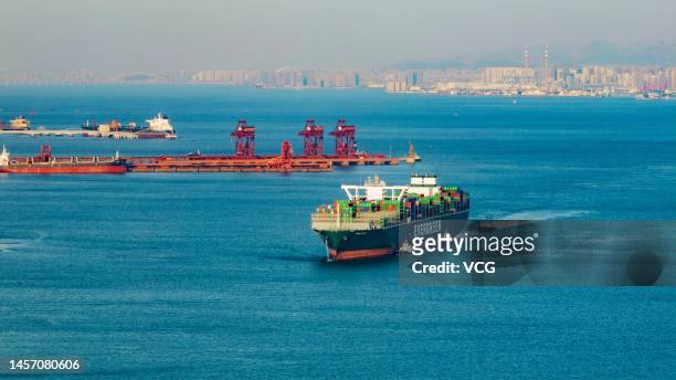 Aerial view of a cargo ship carrying containers entering Qingdao Qianwan Container Terminal on January 16, 2023 in Qingdao, Shandong Province of...