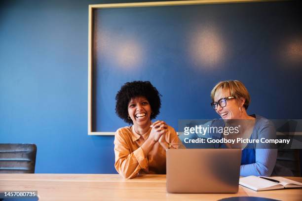 diverse businesswomen laughing while working together in an office board room - 2 ladies table computer stock pictures, royalty-free photos & images