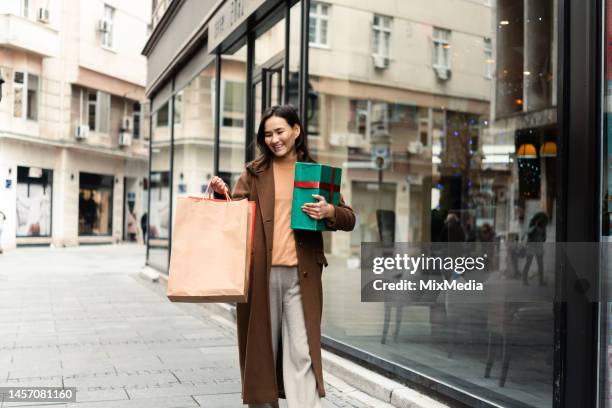 happy asian woman in shopping buying some gifts - center for asian american media stock pictures, royalty-free photos & images