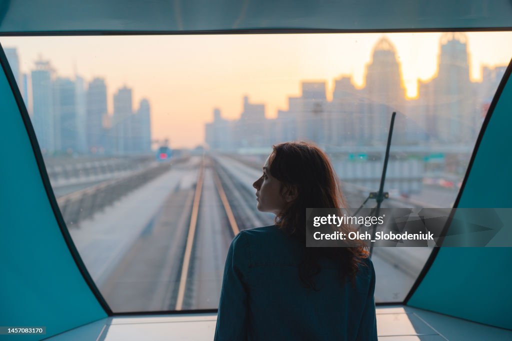 Woman traveling in Dubai metro at sunset