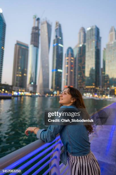 woman walking in dubai marina at sunset - dubai tourist stock pictures, royalty-free photos & images