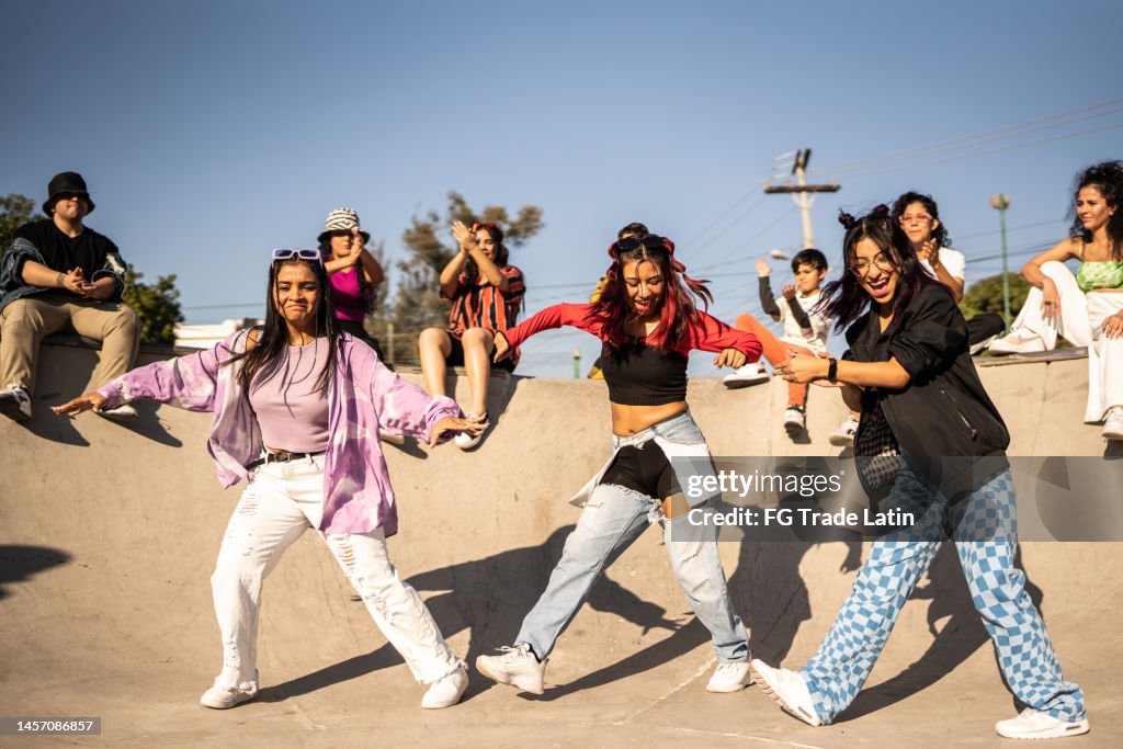 Friends dancing and having fun during street party at skateboard park