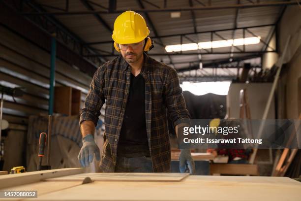 carpenter working on woodworking machines in carpentry shop. profession, carpentry, woodwork and people concept - wood shaving stock pictures, royalty-free photos & images