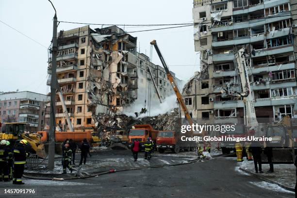 Rescuers search people trapped under the rubble of a high-rise residential building hit by a missile on January 15, 2023 in Dnipro, Ukraine. Since...