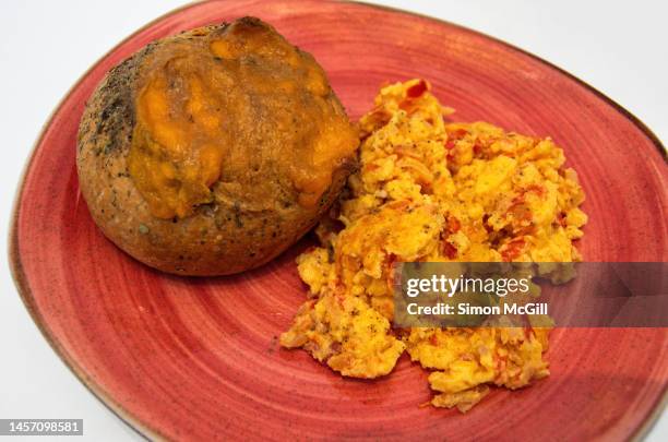 pan de ajo con especias y cheddar fundido y huevos revueltos con tomate [garlic herbed bread roll with melted cheddar cheese and scrambled eggs with tomatoes] - especias stock-fotos und bilder