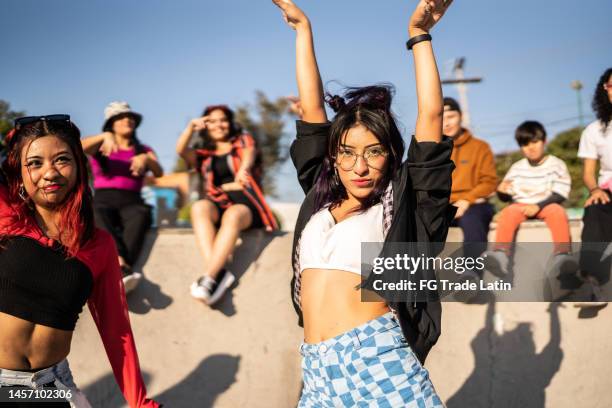 portrait of young woman dancing with her friends at street party - fun band stock pictures, royalty-free photos & images