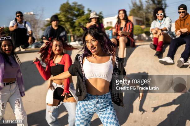 young woman dancing with her friends at street party - fun band stock pictures, royalty-free photos & images