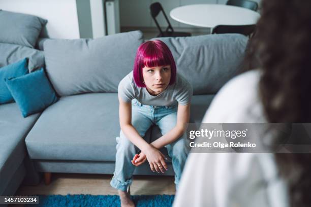 trust problem in family. teen girl looking at an unrecognizable woman with anger, sitting on a couch - critic stock pictures, royalty-free photos & images