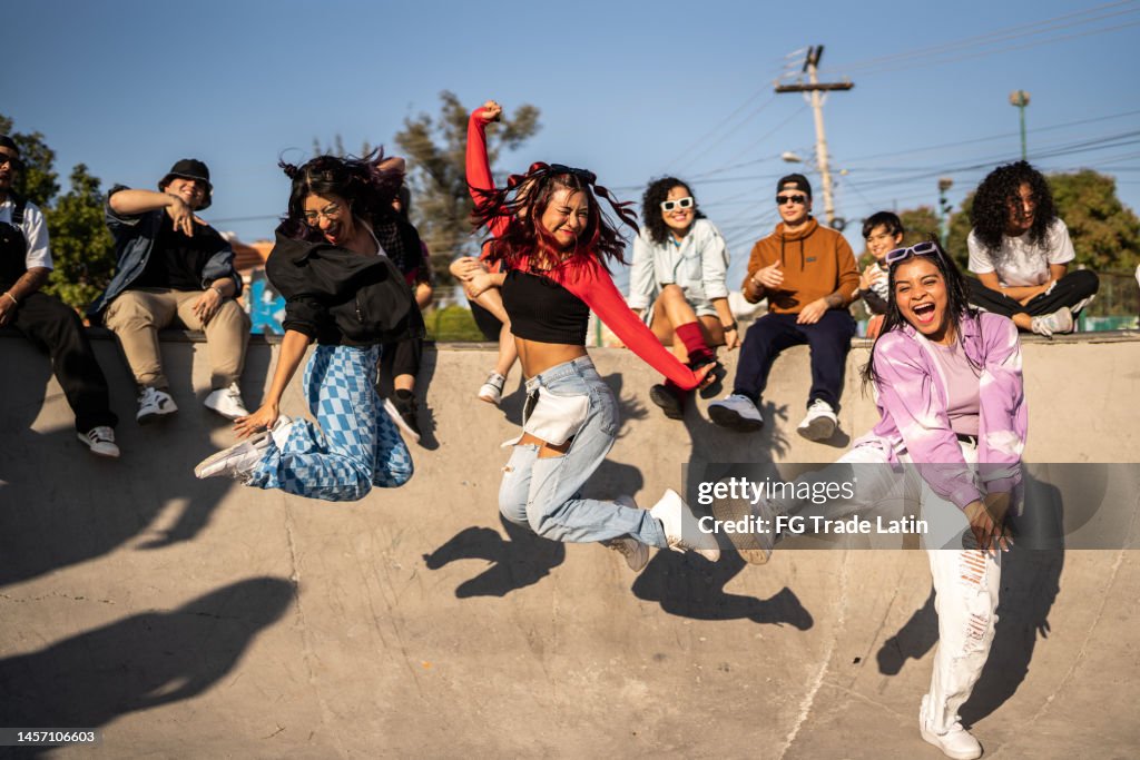 Friends jumping and having fun during street party at skateboard park