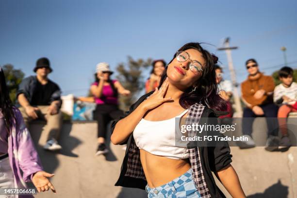 portrait of young woman dancing hip hop at street party - gangsta rappers stock pictures, royalty-free photos & images