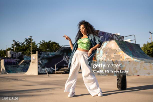 mujer adulta media bailando reggaetón en un parque de patinetas - hip hop dance fotografías e imágenes de stock