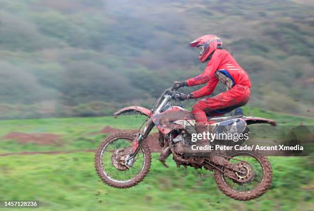 man jumps his motocross bike on stormy day - motocross photos et images de collection