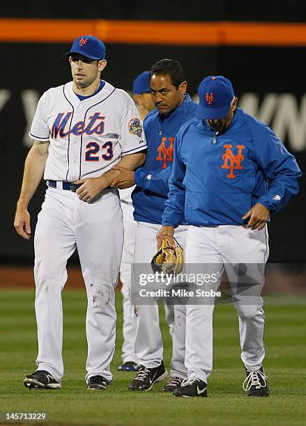 Head Trainer Ray Ramirez and manager Terry Collins walk Mike Baxter of the New York Mets back to the dugout after being injured crashing into the...