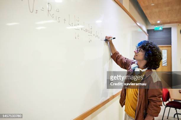 stem student writing equation on whiteboard - mathematician stockfoto's en -beelden