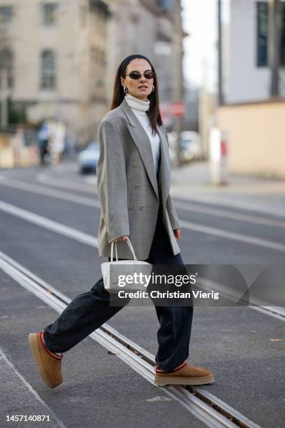 Anna Winter wears grey vintage blazer, Uterque turtleneck, Weekday jeans, UGG boots in brown, Balenciaga sunglasses, white Bottega Veneta bag during...