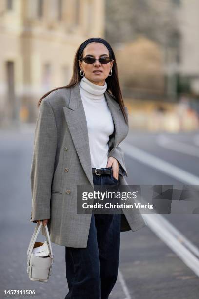 Anna Winter wears grey vintage blazer, Uterque turtleneck, Weekday jeans, UGG boots in brown, Balenciaga sunglasses, white Bottega Veneta bag during...