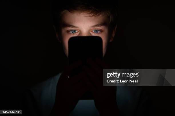 In this photo illustration, a teenage child looks at the screen of a mobile phone on January 17, 2023 in London, England. The 'Online Safety' Bill...