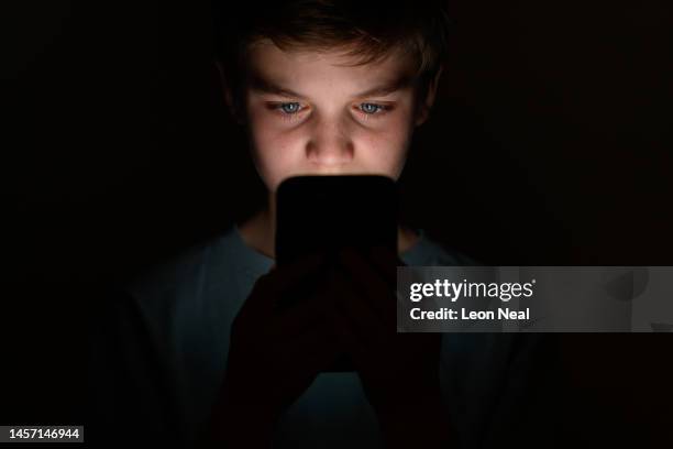 In this photo illustration, a teenage child looks at the screen of a mobile phone on January 17, 2023 in London, England. The 'Online Safety' Bill...