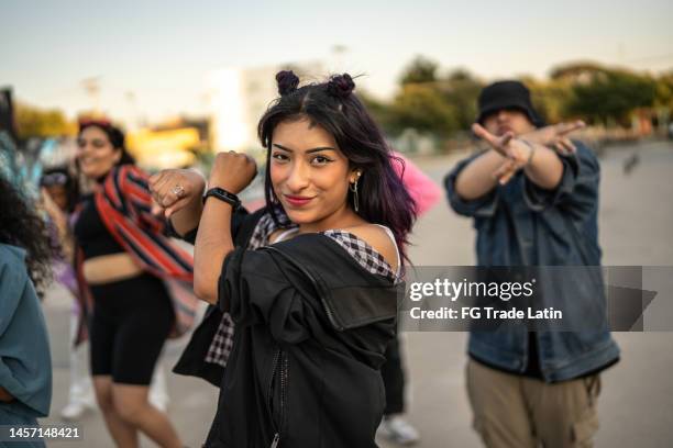 mujer joven bailando hip hop con sus amigos al aire libre - hip hop music fotografías e imágenes de stock