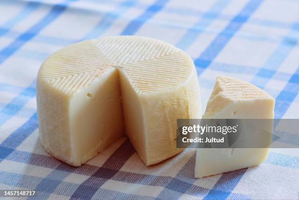 semi-soft cheese open on classic blue chequered tablecloth - käselaib stock-fotos und bilder