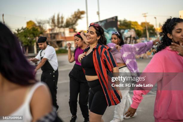 mujer joven bailando y divirtiéndose con sus amigos en el parque de patinetas - hip hop music fotografías e imágenes de stock
