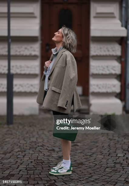 Victoria Thomas seen wearing a beige Blazer from The Frankie Shop, a black short from Bershka, HERNAMEIS the label white socks, green Autry's sneaker...