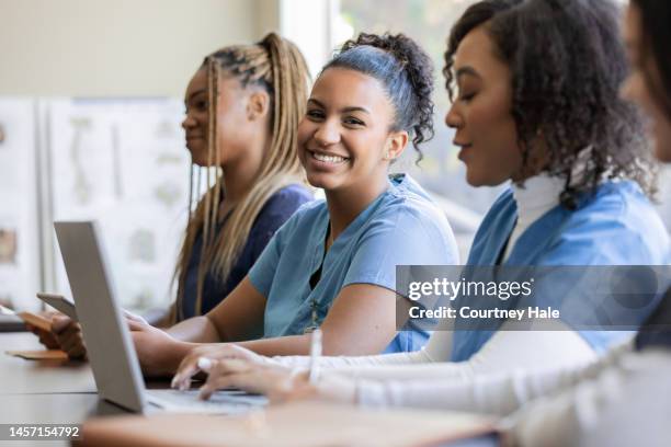 young nurse or medical intern uses laptop computer with classmate during university training class - estudante de medicina imagens e fotografias de stock